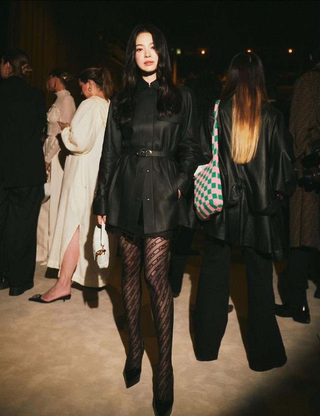 Song Hye Kyo tampak mengenakan mini dress hitam berpotongan tailoring dari material kulit. Aktris 40 tahun ini memadukannya dengan stocking berwarna senada. Foto: Instagram/@kyo1122