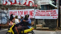 Warga melintas di depan spanduk terkait Tragedi Kanjuruhan di Jl Joglo Raya, Jakarta Barat, Jumat (21/10/2022).