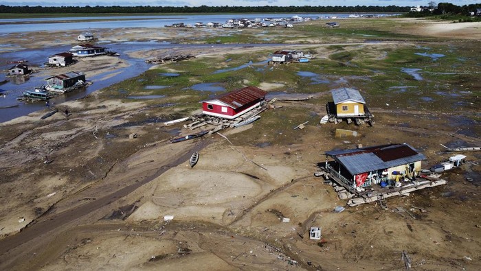 Houseboats sit amid drought-impacted land near the Solimões River, in Tefe, Amazonas state, Brazil, Wednesday, Oct. 19, 2022. Months after enduring floods that destroyed crops, thousands of families in the Brazilian Amazon are now dealing with severe drought. (AP Photo/Edmar Barros)