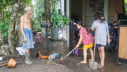 Warga Desa Jungutan, Kecamatan Bebandem, Kabupaten Karangasem, Bali, saat melakukan pembersihan sisa lumpur yang masuk halaman rumahnya, Jumat (21/10/2022).