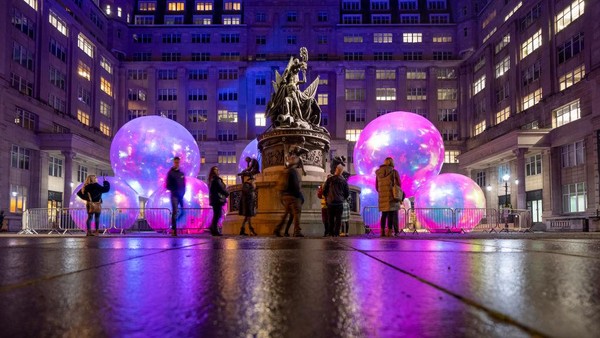 Sejumlah warga melihat instalasi yang berbentuk bola raksasa di Liverpool, Inggris, Kamis (20/10/2022).