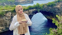 Wanita 23 tahun ini merayakan ulang tahunnya dengan cara istimewa. Ia membawa sepotong kue dan berfoto dengan latar pemandangan alam yang cantik.