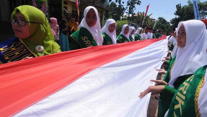 KIRAB MERAH PUTIH HARI SANTRI NASIONAL Peserta membentangkan kain merah putih saat mengikuti Kirab Merah Putih di Kacangan, Andong, Boyolali, Jawa Tengah, Sabtu (22/10/2022). Selain untuk memeriahkan Hari Santri Nasional, kirab dengan membentangkan kain merah putih sepanjang 1.000 meter yang dilakukan para santri dan pengurus Pondok Pesantren Salafiyah Darussalam Kacangan itu juga bertujuan untuk menanamkan rasa cinta kepada NKRI. ANTARA FOTO/Aloysuis Jarot Nugroho/nym.