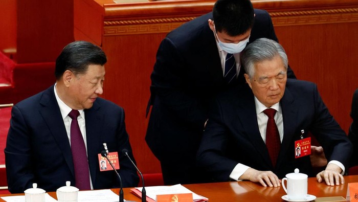 Former Chinese president Hu Jintao is assisted at his seat next to Chinese President Xi Jinping, during the closing ceremony of the 20th National Congress of the Communist Party of China, at the Great Hall of the People in Beijing, China October 22, 2022. REUTERS/Tingshu Wang