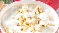 Ide menikmati makanan mirip sereal nih! Isinya bukan sereal, melainkan popcorn. Guyuran susu segarnya merendam popcorn hingga empuk.