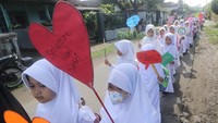 Sejumlah pelajar membawa poster saat mengikuti pawai Hari Santri Nasional di Desa Tugurejo Kediri, Jawa Timur, Sabtu (22/10/2022).  ANTARA FOTO/Prasetia Fauzani