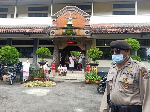 Personel kepolisian dari Polsek Denpasar Utara tampak berpatroli di lingkungan SMPN 5 Denpasar, Sabtu (22/10/2022).