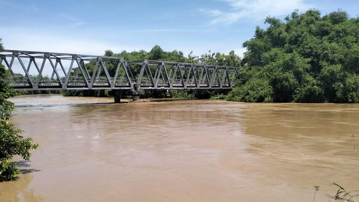 Polisi saat mengecek debit air di Sungai Madiun yang melintasi Ngawi