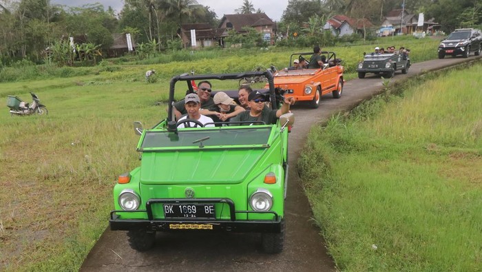 WISATA VW SAFARI MAGELANG Wisatawan menaiki mobil Volkswagen (VW) dengan latar belakang Candi Pawon di Magelang, Jawa Tengah, Jumat (21/10/2022). Wisata menyusuri desa di lereng pegunungan Menoreh menggunakan mobil klasik tersebut menawarkan pemandangan pedesaan dan sejumlah candi dengan harga Rp400 ribu hingga Rp1 juta per paket. ANTARA FOTO/Prasetia Fauzani/nz