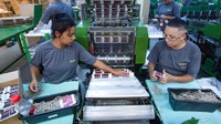 Dengan hati-hati dan teliti, pekerja mengemas stiker para pemain yang berlaga di Piala Dunia 2022 tersebut.