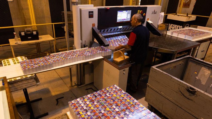 Begini Pembuatan Stiken Keren Piala Dunia 2022, Cocok Buat Koleksi SAO PAULO, BRAZIL - OCTOBER 19: An employee cuts sheets of stickers on the production line of FIFA World Cup Qatar 2022 stickers album at Panini factory on October 19, 2022 in Sao Paulo, Brazil. (Photo by Alexandre Schneider/Getty Images)