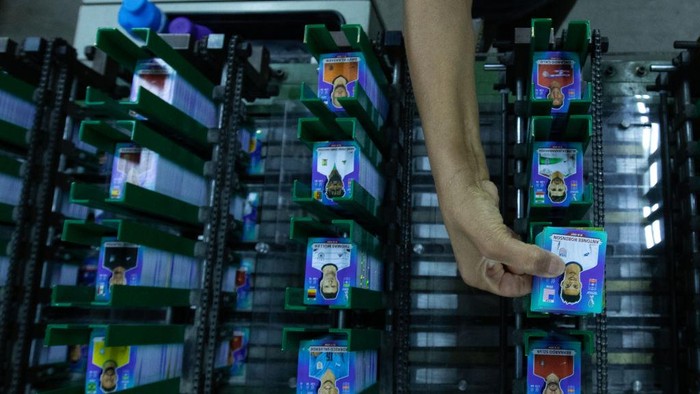 Begini Pembuatan Stiken Keren Piala Dunia 2022, Cocok Buat Koleksi SAO PAULO, BRAZIL - OCTOBER 19: An employee cuts sheets of stickers on the production line of FIFA World Cup Qatar 2022 stickers album at Panini factory on October 19, 2022 in Sao Paulo, Brazil. (Photo by Alexandre Schneider/Getty Images)