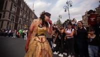 Seorang wanita berpakaian zombie mengikuti Zombie Walk tahunan di Mexico City, Meksiko, Sabtu, (22/10/2022).