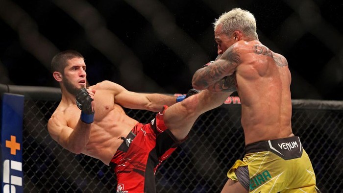 Momen Islam Makhachev Kalahkan Oliveira dan Raih Sabuk Juara Islam Makhachev (L) competes against Charles Oliveira in the lightweight championship at the Ultimate Fighting Championship (UFC) event at the Etihad Arena in Abu Dhabi on October 22, 2022. (Photo by Giuseppe CACACE / AFP) (Photo by GIUSEPPE CACACE/AFP via Getty Images)