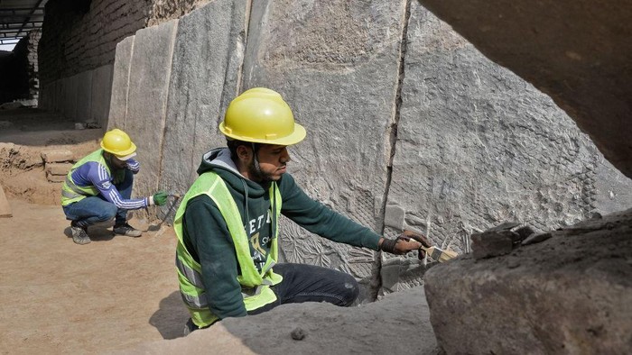 Iraqi workers excavate a rock-carving relief recently found at the Mashki Gate, one of the monumental gates to the ancient Assyrian city of Nineveh, on the outskirts of what is today the northern Iraqi city of Mosul on October 19, 2022. (Photo by Zaid AL-OBEIDI / AFP) (Photo by ZAID AL-OBEIDI/AFP via Getty Images)
