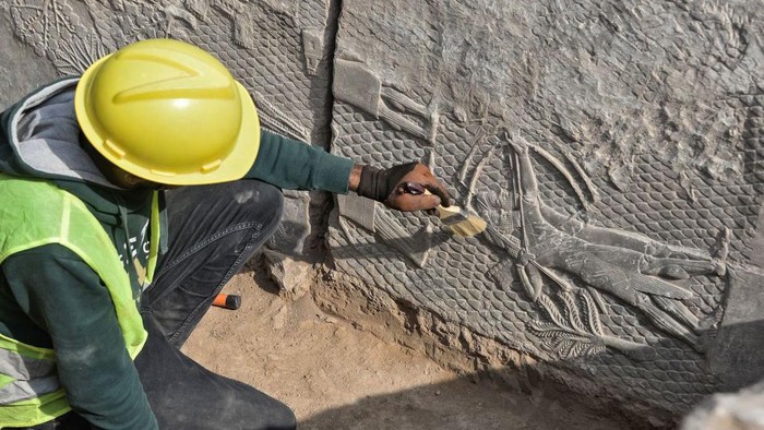 Iraqi workers excavate a rock-carving relief recently found at the Mashki Gate, one of the monumental gates to the ancient Assyrian city of Nineveh, on the outskirts of what is today the northern Iraqi city of Mosul on October 19, 2022. (Photo by Zaid AL-OBEIDI / AFP) (Photo by ZAID AL-OBEIDI/AFP via Getty Images)