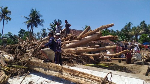 Pembersihan kayu dan lumpur di rumah warga Bilukpoh, Jembrana, Bali, pascabanjir bandang.