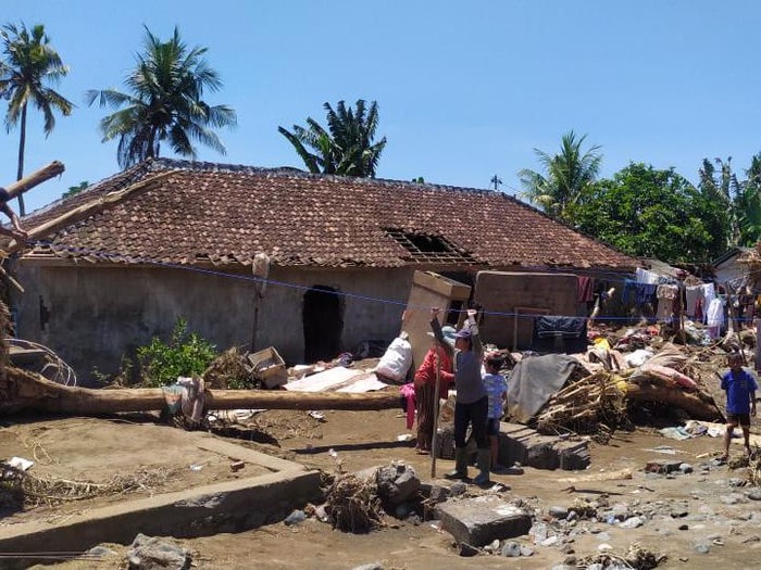 Pembersihan kayu dan lumpur di rumah warga Bilukpoh, Jembrana, Bali, pascabanjir bandang.