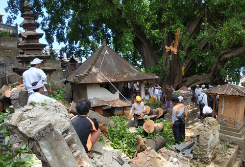 Petugas BPBD Kabupaten Karangasem saat melakukan penanganan dahan pohon yang patah dan menimpah 16 palinggih di Pura Dadia Beten Aas, Minggu (23/10/2022). (istimewa)
