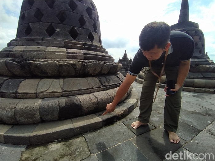 Petugas menunjukkan goresan tanda bintang penanda stupa yang pernah rusak akibat serangan bom di Candi Borobudur.
