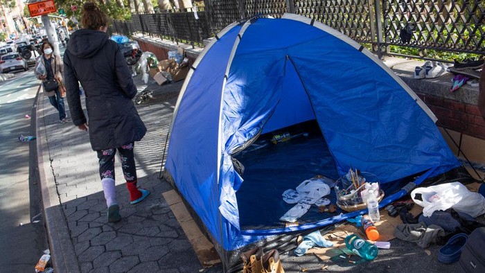 NEW YORK, NY - OCTOBER 12: A small group of homeless who have received a notice from the city of a scheduled sweep of their encampment move their belongings across the street, October 12, 2022, in the Chinatown neighborhood of New York City, New York. (Photo by Andrew Lichtenstein/Corbis via Getty Images)