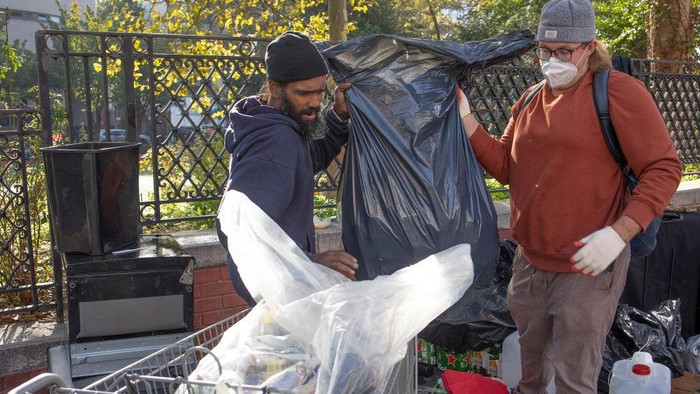NEW YORK, NY - OCTOBER 12: A small group of homeless who have received a notice from the city of a scheduled sweep of their encampment move their belongings across the street, October 12, 2022, in the Chinatown neighborhood of New York City, New York. (Photo by Andrew Lichtenstein/Corbis via Getty Images)