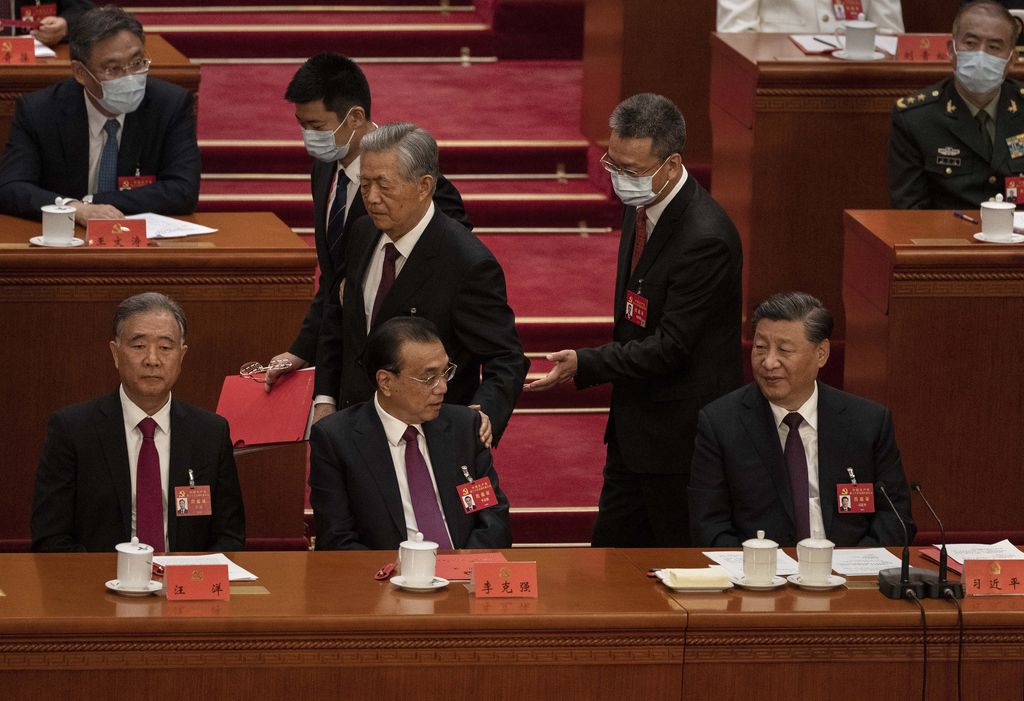 Presiden China Xi Jinping dan Perdana Menteri Li Keqiang, kiri, dan anggota Politbiro Wang Yang terlihat saat mantan Presiden Hu Jintao, tengah, berbicara kepada mereka saat dia dibantu untuk pergi lebih awal dari sesi penutupan tanggal 20 Kongres Nasional Partai Komunis Tiongkok, di Aula Besar Rakyat pada 22 Oktober 2022 di Beijing, Tiongkok. (Getty Images/Kevin Frayer)