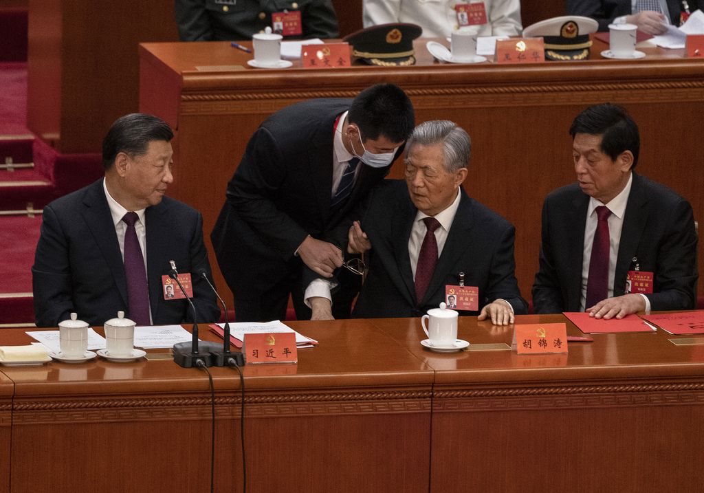 Presiden China Xi Jinping, kiri bawah, Li Zhanshu, dan Wang Huning, kanan, tampak saat mantan Presiden Hu Jintao, tengah, dibantu untuk pergi lebih awal dari sesi penutupan Kongres Nasional ke-20 Partai Komunis Tiongkok, di Aula Besar Rakyat pada 22 Oktober 2022 di Beijing, Tiongkok. (Getty Images/Kevin Frayer)