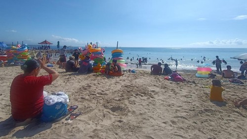 Putri Pratiwi (35), tengah bersembahyang sebelum memulai ritual Banyu Pinaruh, di Pantai Sanur, Denpasar, Bali, Minggu (23/10/2022).