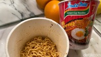 Sebelum bumbu dituang, mie disaring lebih dulu dengan garpu plastik yang ada di dalam kemasan. Baru bumbu dituang dan diaduk hingga rata.  Foto: detikFood
