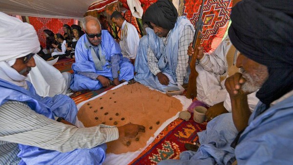 Penduduk Sahrawi memainkan Dama atau Dhamet, permainan strategi tradisional di kamp pengungsi Awsard di Tindouf di barat daya Aljazair (13/10/2022).