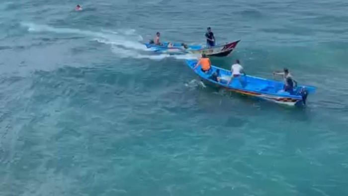 Tim SAR Satlinmas Wilayah II Kabupaten Gunungkidul saat melakukan evakuasi terhadap enam wisatawan yang terseret ombak di Pantai Ngandong. Minggu (23/10/2022).