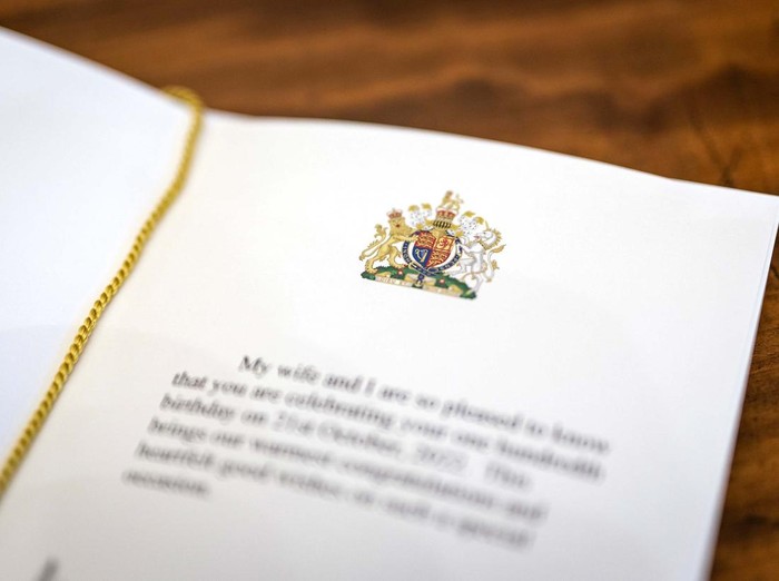 LONDON, ENGLAND - OCTOBER 23: A close-up of the message inside one of the first birthday cards celebrating 100 years of age, which have been signed by King Charles III and Camilla, Queen Consort at Buckingham Palace on October 23, 2022 in London, England. The posting of messages to mark significant birthdays and anniversaries is a tradition that dates back to 1917 and the reign of King George V, when those celebrating their 100th birthday or 60th wedding anniversary were sent a telegram of good wishes from His Majesty. Thousands of birthday and wedding anniversary cards are sent from Buckingham Palace every year to those celebrating their 100th and 105th birthday and every year thereafter, and to those celebrating their 60th , 65th, 70th wedding anniversaries and every year thereafter. During Queen Elizabeth IIs reign, approximately 1.3 million cards were sent to mark birthdays and anniversaries across the UK, the Realms and the Overseas Territories. The photograph of The King and The Queen Consort that appears on the birthday cards was taken in the summer of 2018.  (Photo by Aaron Chown-WPA Pool/Getty Images)