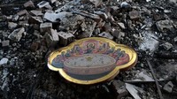Hiasan dinding tergeletak di atas puing-puing yang sebelumnya merupakan rumah warga. Foto: SOPA Images/LightRocket via Gett/SOPA Images