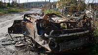 Sebuah mobil yang hangus terbakar teronggok di pinggir jalan. Foto: SOPA Images/LightRocket via Gett/SOPA Images