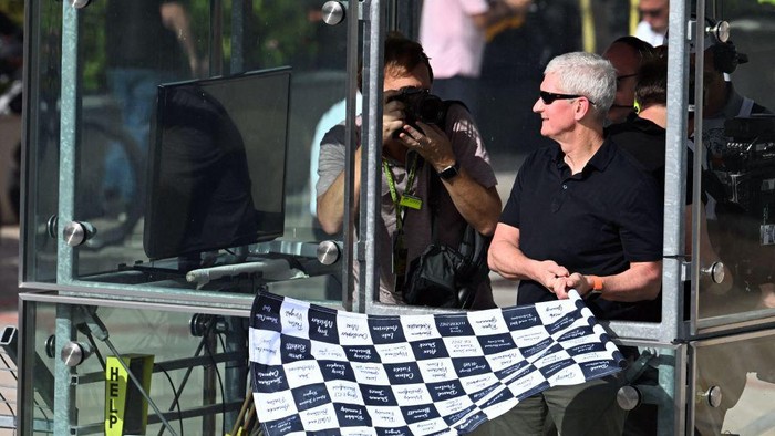 Apple CEO Tim Cook waves the checkered flag at the end of the Formula One United States Grand Prix, at the Circuit of the Americas in Austin, Texas, on October 23, 2022. (Photo by Jim WATSON / AFP) (Photo by JIM WATSON/AFP via Getty Images)