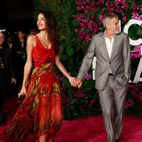 Wanita yang berprofesi sebagai pengacara hak asasi manusia itu terlihat membawa clutch gold dan memakai high heels PVC transparan serta perhiasan Cartier untuk membuat penampilannya terlihat glamour. Foto: Michael Tran/AFP/Getty Images