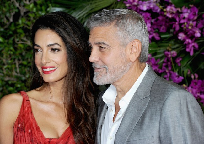 Amal Clooney memadukan dress merah Alexander McQueen dengan lipstik yang warnanya senada dengan busananya. Makeup bold jadi pilihannya di premier film George Clooney. Foto: Albert L. Ortega/Getty Images