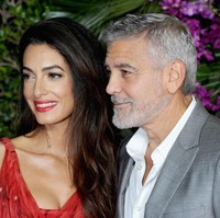 Amal Clooney memadukan dress merah Alexander McQueen dengan lipstik yang warnanya senada dengan busananya. Makeup bold jadi pilihannya di premier film George Clooney. Foto: Albert L. Ortega/Getty Images