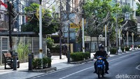 Pengendara melintas di sekitar kabel semrawut di Jalan Wolter Monginsidi, Jakarta Selatan.