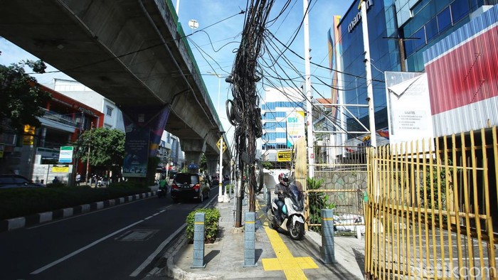 Duh Kabel Semrawut di Wolter Monginsidi Belum 'Dikubur' Pengendara melintas di jalan Wolter Monginsidi, Jakarta Selatan, Senin (24/10/2022). Nampak kabel masih terlihat semrawut di atas trotoar yang telah direvitalisasi.