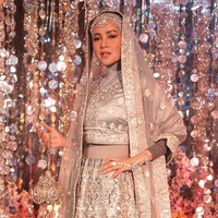 Olla Ramlan tampil berhijab dan menyulap baju tradisional India yang dikenakannya terlihat lebih syar’i. Sang aktris memakai manset di balik atasan crop top abu-abu dan membawa tas kecil serasi yang mengkilap. Foto: Instagram