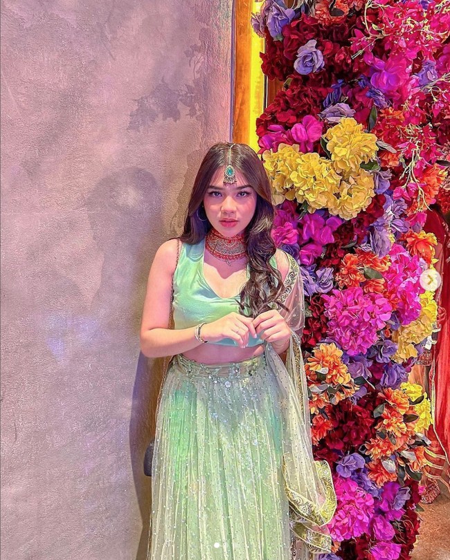 Devina Karamoy membuat busana tradisional India lebih modern. Pemain film Jin & Jun The Movie itu memadukan sleeveless crop top warna tosca dengan rok panjang hijau dengan aksen manik-manik. Dia juga memakai aksesoris khas wanita India seperti kalung besar di lehernya. Foto: Instagram