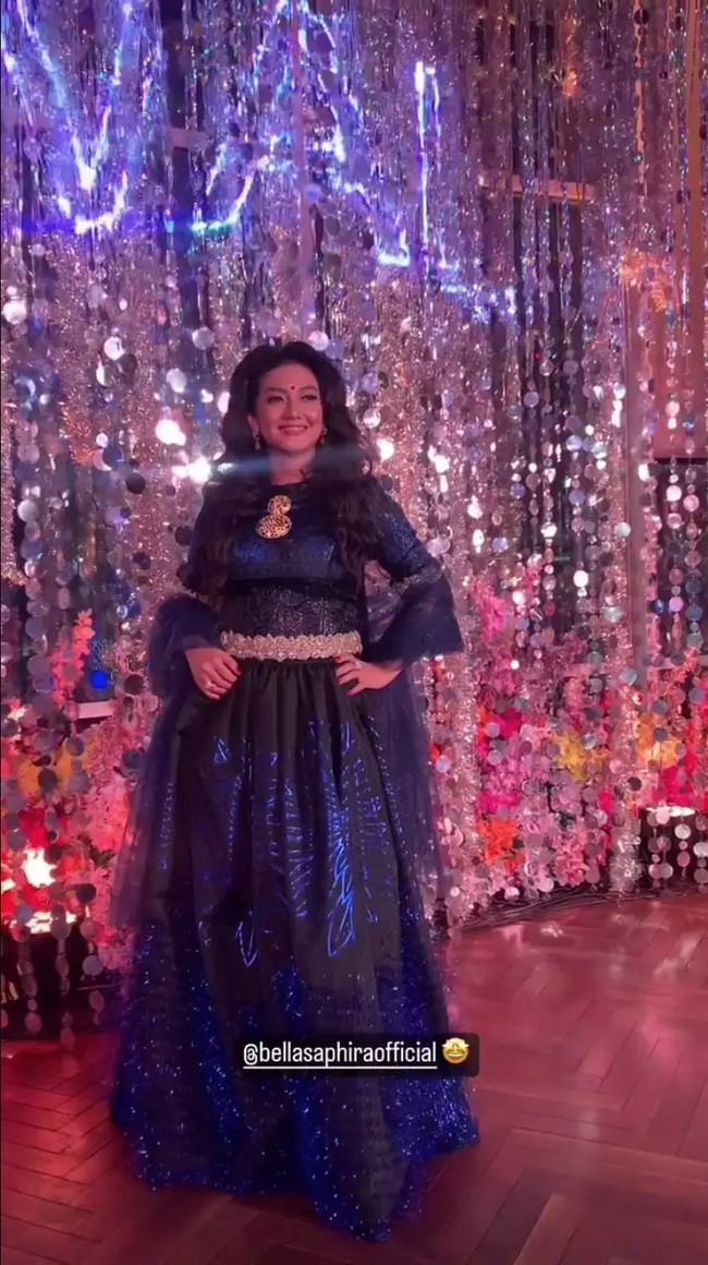 Ada pula Bella Saphira yang menggerai rambut panjangnya dan menambahkan tanda bulat merah alias bindi di keningnya. Dia tampil glamor memakai gaun biru dengan aksen renda gold pada bagian pinggang. Foto: Instagram