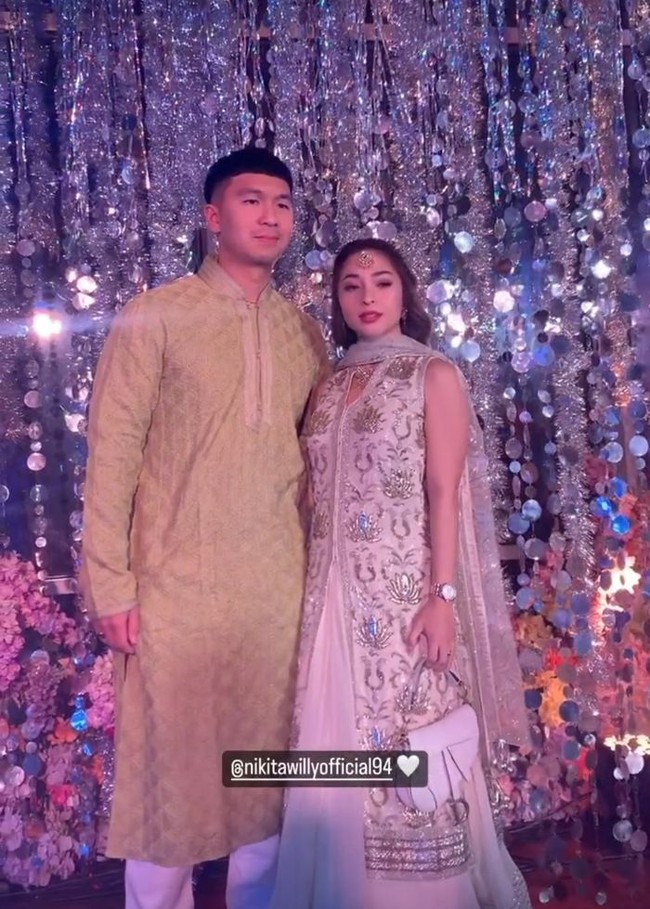 Nikita Willy yang hadir bersama suaminya Indra Priawan tampil bak bintang Bollywood. Dia memakai gaun abu-abu yang kental dengan aksen India, lengkap dengan syal dan aksesori di tengah keningnya. Sedangkan Indra Priawan memakai baju tradisional India untuk pria, kurta pyjama. Foto: Instagram