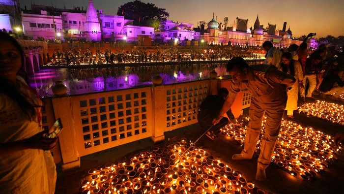 People light lamps on the banks of the river Saryu in Ayodhya, India, Sunday, Oct. 23, 2022. Over 15,00,000 earthen lamps were lit along the banks of the Saryu River, as millions of people across Asia celebrate Diwali, the Hindu festival of lights. (AP Photo/Rajesh Kumar Singh)
