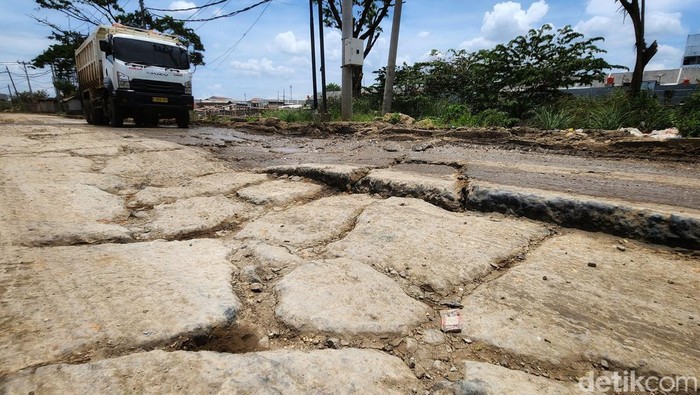 Mobil pribadi dan truk melintas di Jalam Perancis, Dadap, Kosambi, Tangerang, Senin (24/10/2022). Jalan yang sudah dibeton tersebut terpantau rusak parah dalam beberapa bulan terakhir. Jika hujan, jalanan menjadi kubangan lumpur dan saat matahari terik diselimuti debu.