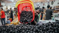 Seorang penjual menuangkan kurma dari keranjang untuk dijual. Kurma yang dijual merupakan kurma asli yang dipanen dari kebun tersebut.