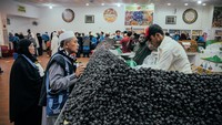 Sepasang suami istri asal WNI membeli kurma. Wisata kebun kurma ini masih menjadi daya tarik bagi jemaah haji dan umrah, khususnya jemaah dari Indonesia.