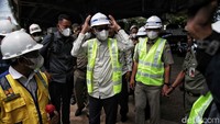 Heru langsung dipakaikan alat pelindung diri (APD) berupa rompi dan topi sebelum memasuki area proyek. 